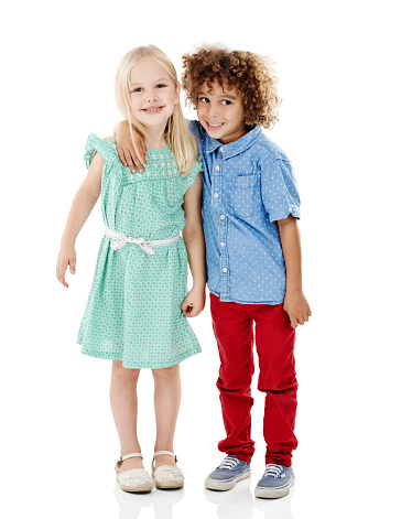 Studio shot of a cute little boy and girl posing together against a white background