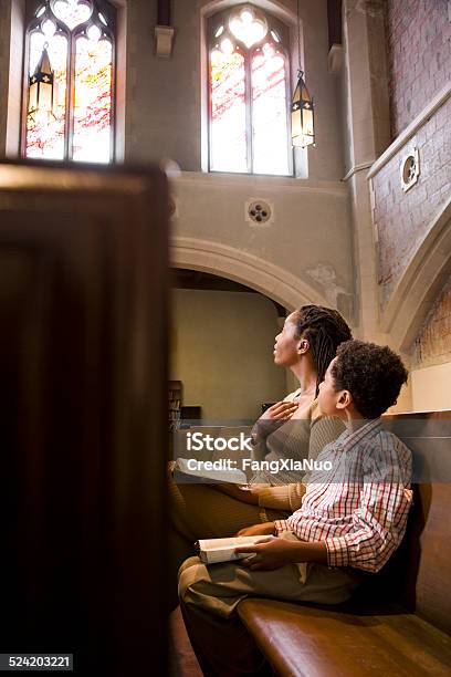 Mother And Son Praying From Bible In Church Stock Photo - Download Image Now - Church, Praying, People