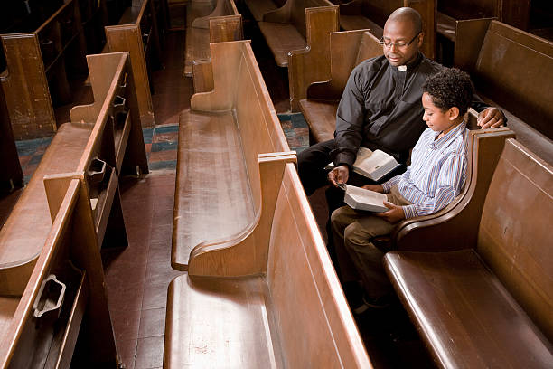 iglesia sacerdote y niño en banco de iglesia perteneciente a la lectura bible - protestantismo fotografías e imágenes de stock