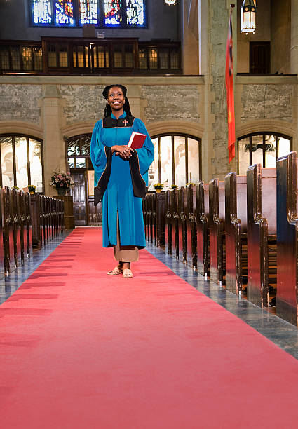 Woman Clergy Member Walking Down Church Aisle Woman Clergy Member Walking Down Church Aisle clergy stock pictures, royalty-free photos & images