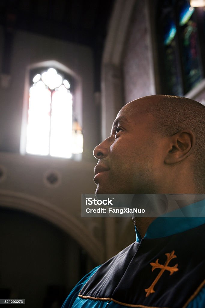 Male Church Member Praying During Service Minister - Clergy Stock Photo