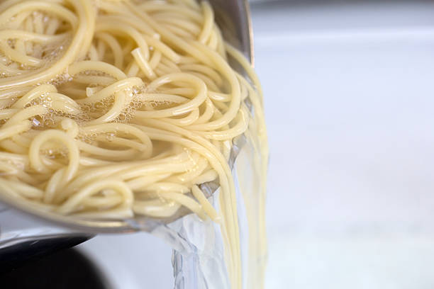 Cooking spaghetti noodles meal strain the pasta from hot water