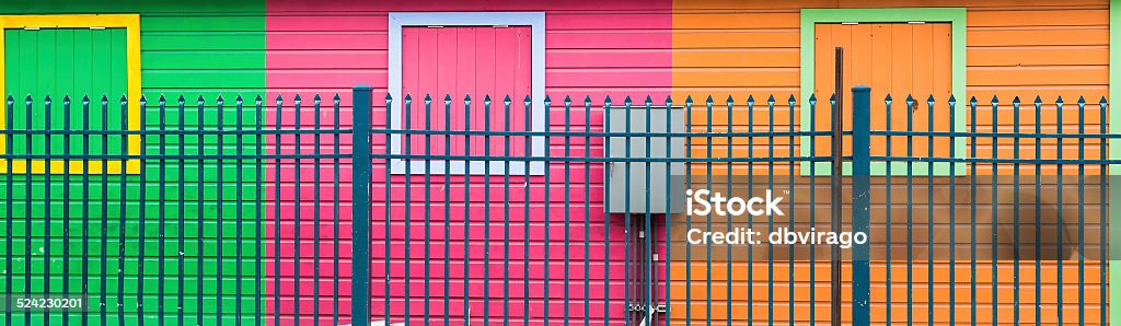 Blue Fence by Colorful Walls Bright colorful walls behind blue fence in Nassau, Bahamas Architecture Stock Photo
