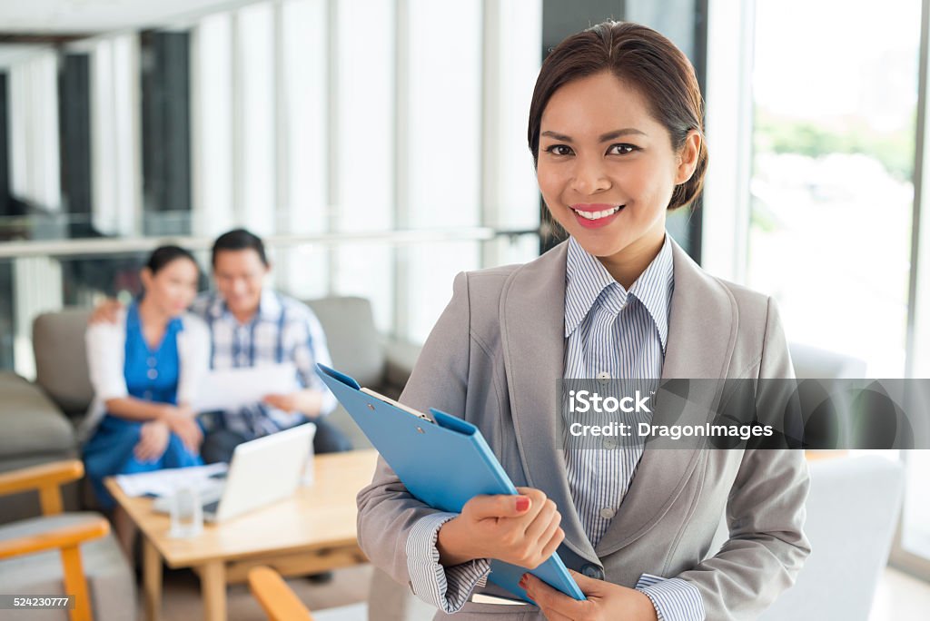 Cheerful estate agent Portrait of cheerful real estate agent with a clipboard Mortgage Document Stock Photo