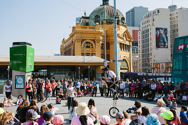 Melbourne Melbourne, Australia - April 9, 2013: Street performer entertaining the crowd at Federation square in Melbourne.Large group of people are watching the show.Many street artists and jugglers are performing at this place every day. melbourne street crowd stock pictures, royalty-free photos & images
