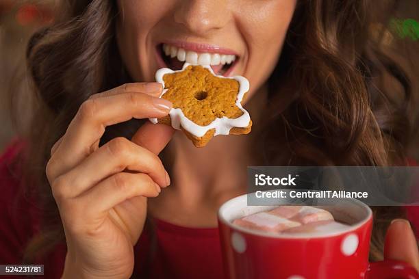 Closeup On Happy Young Woman Eating Christmas Cookie Stock Photo - Download Image Now