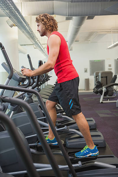 istock Side view of man working out on x-trainer in gym 524258785