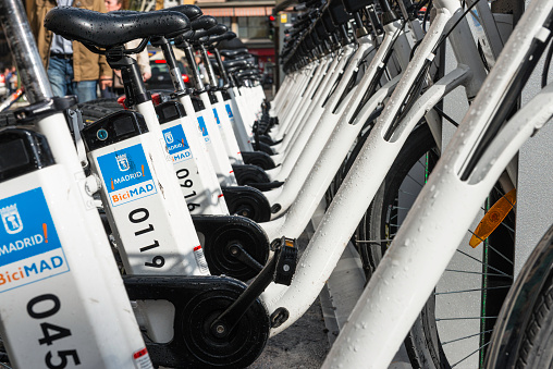 Madrid, Spain - October 11, 2014: Close-up of bikes docked to a BiciMAD station on La Latina district in Madrid, Spain. This electric bicycle sharing public transport service was first introduced in Madrid in Summer 2014, supplied by 100% clean, healthy and sustainable electric bicycles.