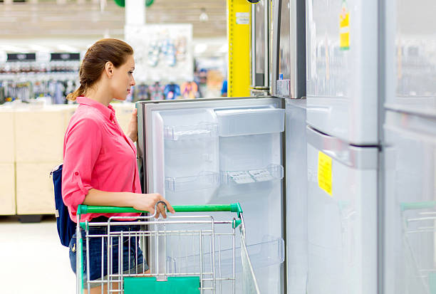 istock woman buys a refrigerator in the store 524288467
