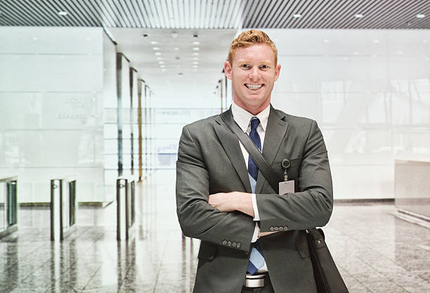 alegre hombre de negocios de pie en la oficina - lobby businessman office building built structure fotografías e imágenes de stock