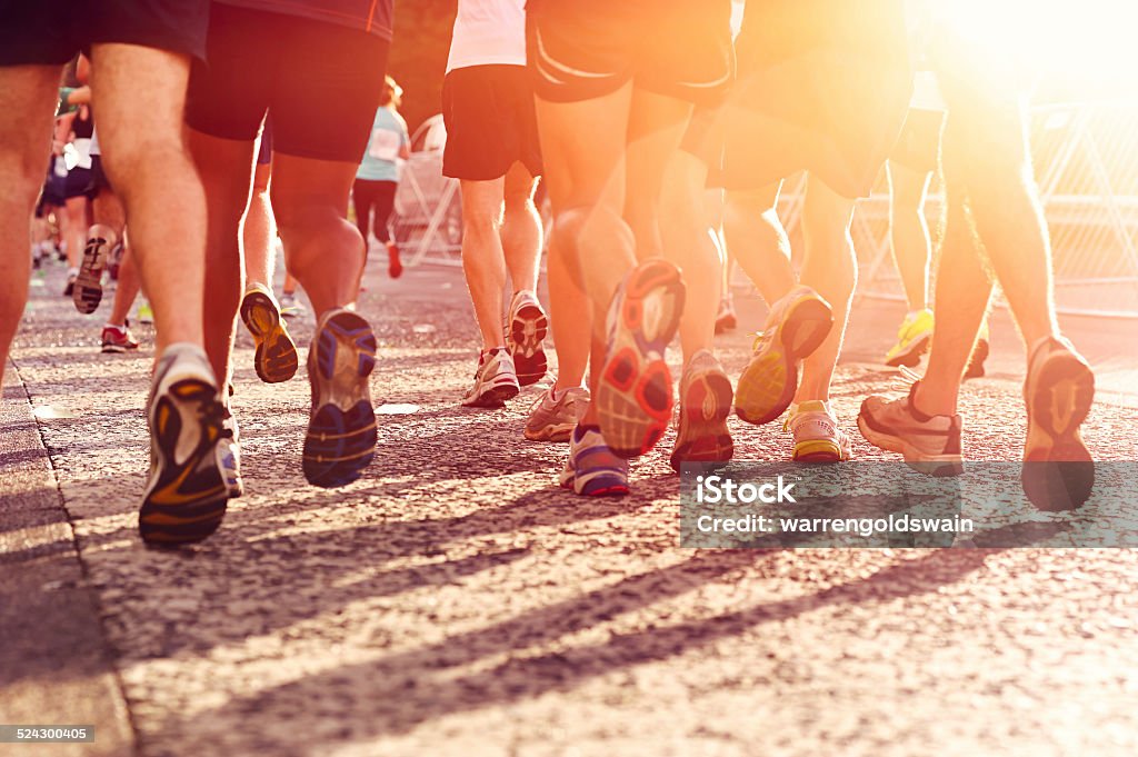 people running marathon Marathon running race people competing in fitness and healthy active lifestyle feet on road Marathon Stock Photo