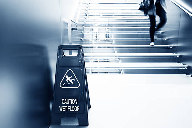 wet floor caution wet floor caution sign near the glass staircase. slippery stock pictures, royalty-free photos & images