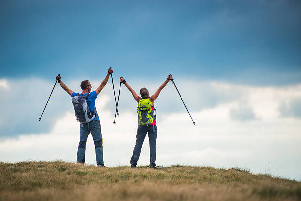 Hikers rejoicing with their arms raised up in the air.   