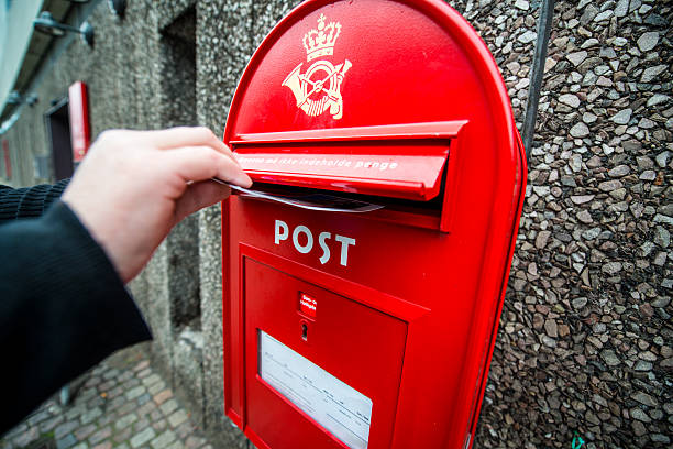 Man putting postcard into mailbox on the street, Copenhagen