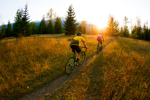 Two male cyclists ride their cyclo-cross bikes on a single track trail in British Columbia, Canada.
