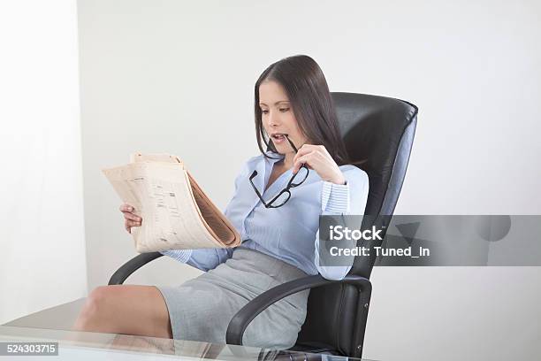 Business Woman Reading Newspaper In Office Stock Photo - Download Image Now - Adult, Adults Only, Asian and Indian Ethnicities