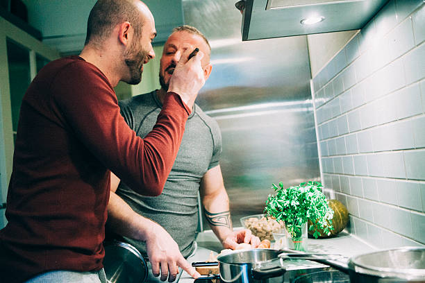 istock gay couple preparing the meal in the kitchen 524303909