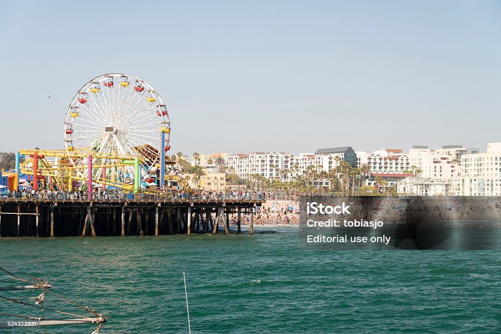 Santa Monica Pier Santa Monica, Los Angeles, California, USA - May 27, 2014: People having fun on the Santa Monica Pier during a sunny day. The Santa Monica Pier is a large pier located at the foot of Colorado Avenue in Santa Monica, California. Amusement Park Stock Photo