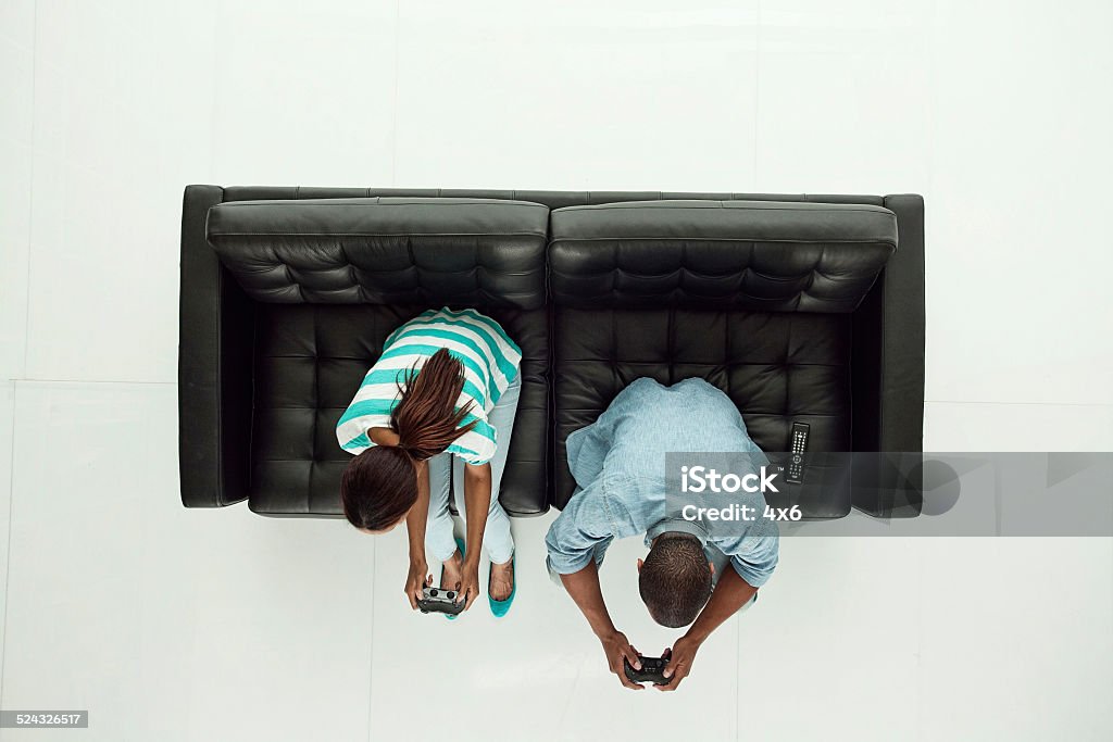 Above view of couple playing video game Above view of couple playing video gamehttp://www.twodozendesign.info/i/1.png Directly Above Stock Photo