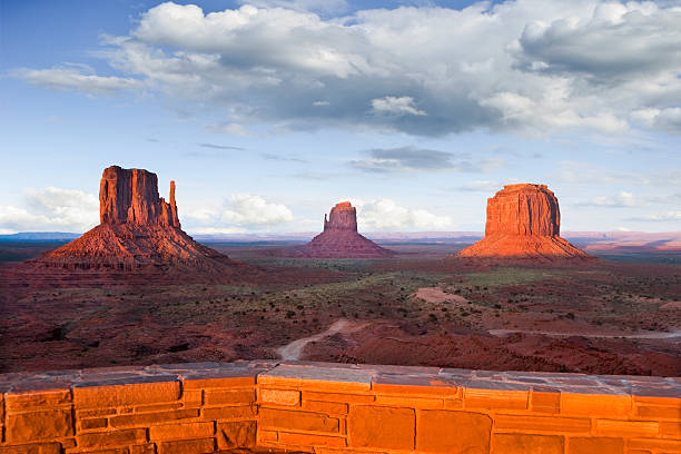 Monument Valley at Sunset from the Visitor Center Monument Valley is on the Arizona/Utah border near Oljato, Utah, USA. The valley with its strange sandstone formations is the epitome of the Old West. This iconic view was taken at sunset, capturing the other-worldly glow on the red rock. jeff goulden monument valley stock pictures, royalty-free photos & images