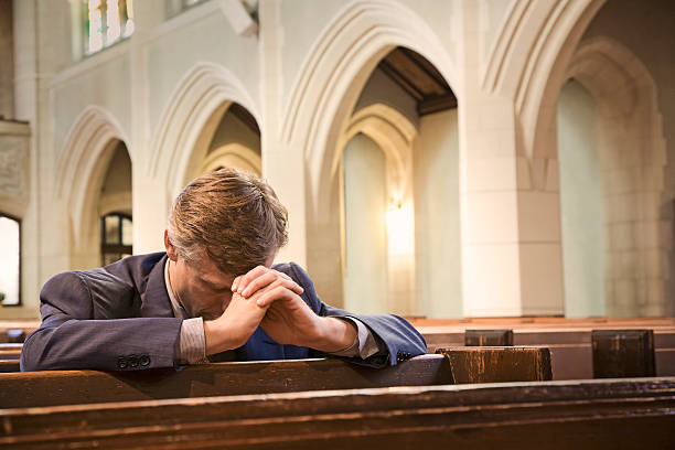 uomo in ginocchio e pregare in chiesa - confession booth foto e immagini stock
