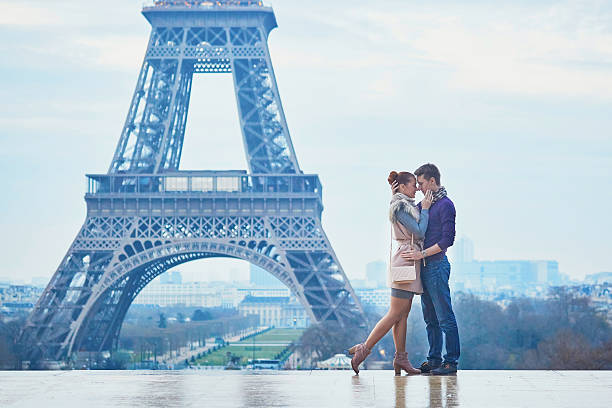 пара возле эйфелевой башни в париже, франция - honeymoon wedding paris france bride стоковые фото и изображения