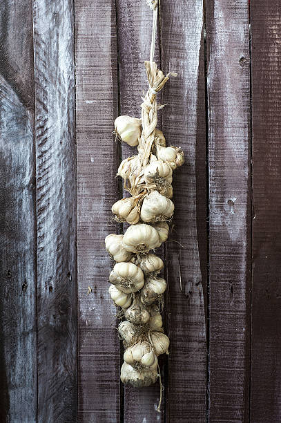 cadeia de alho em fundo de madeira - garlic hanging string vegetable imagens e fotografias de stock