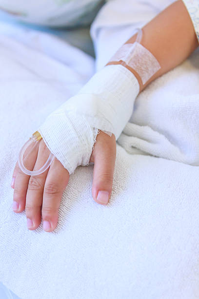 istock Saline intravenous (iv) drip in a child's patient hand. 524373638