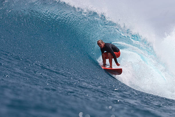 homme est plus sur le vague voûté de style - surfing men hawaii islands wave photos et images de collection