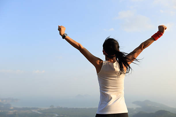 istock young successful woman open arms on mountain peak 524374278