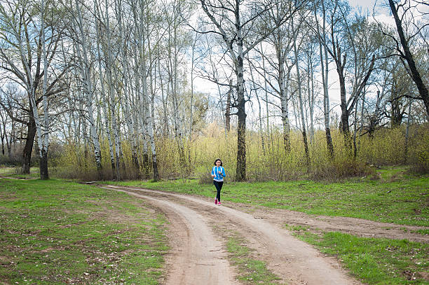 istock slim young woman runner in the woods 524377840