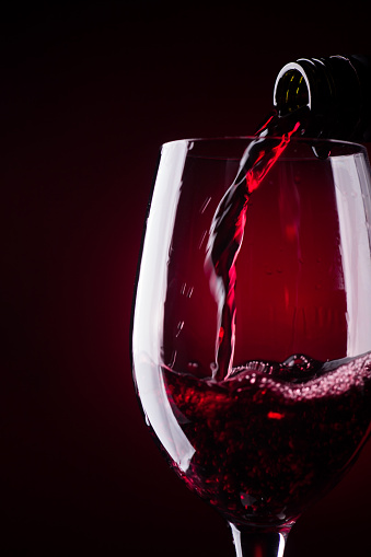 Bottle Pouring Red Wine in a Glass