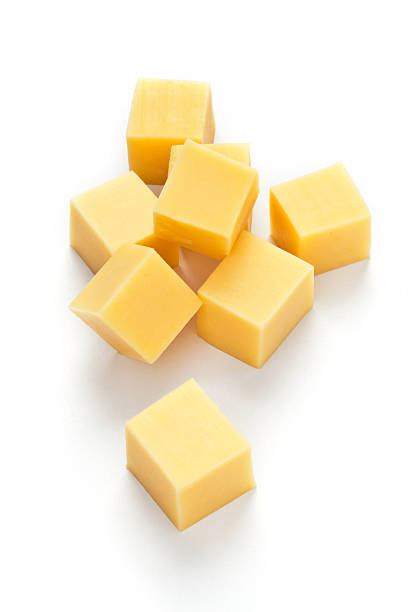 Cheese cubes Yellow cheese cubes isolated on white background. DSRL Studio photo taken with Canon EOS 5D Mark II and EF100mm f/2.8L Macro IS USM Lens cheddar cheese stock pictures, royalty-free photos & images