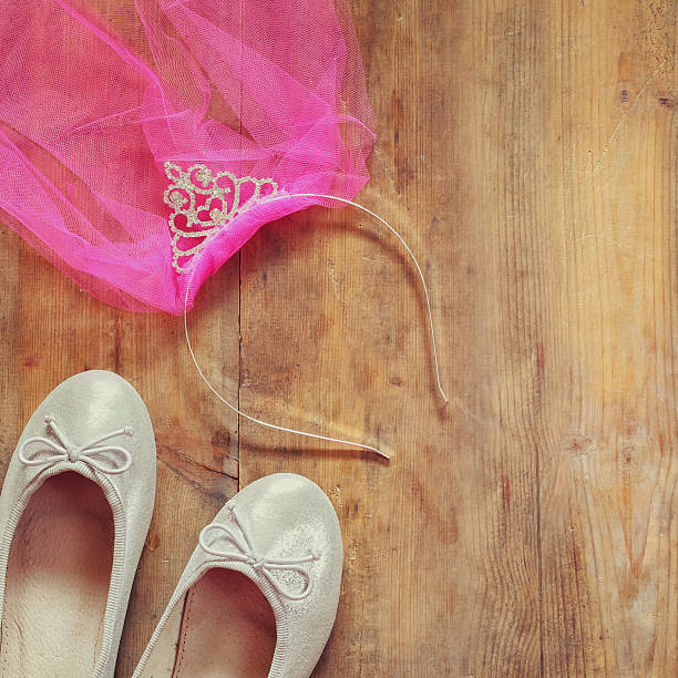 istock girl's diamond tiara with pink  chiffon vail and ballet shoe 524387546