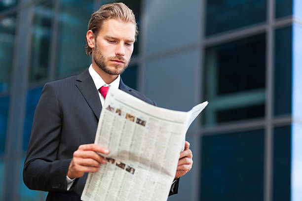 istock handsome businessman holding a newspaper 524388190