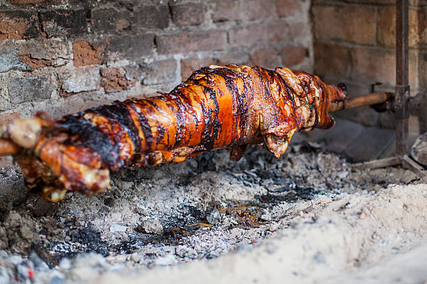 свинья на вертеле - spit roasted pig roasted food стоковые фото и изображения