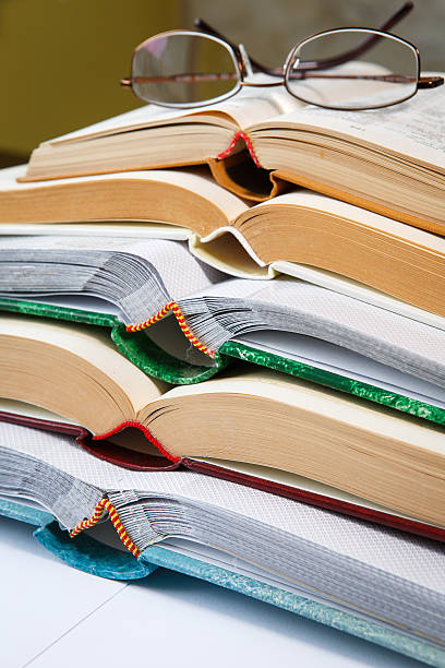 istock Pile of open books and reading glasses 524389102