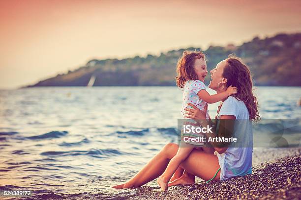Mother And Daughter By The Sea Stockfoto en meer beelden van Strand - Strand, Moeder, Zee