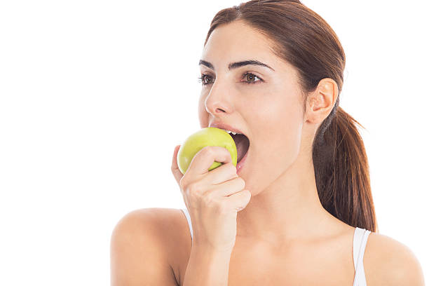 bella ragazza che mangia una mela - apple women green eating foto e immagini stock