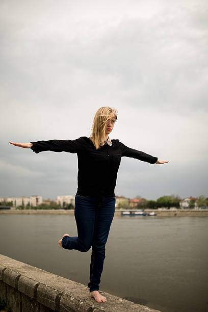 istock Woman balancing on one leg at the riverbank. 524390412