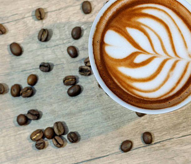 istock Cup of espresso with coffee beam on wooden kitchen table 524391264