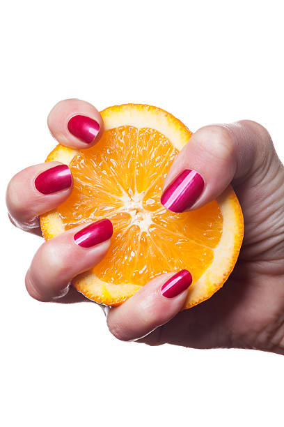 istock Hand with manicured nails touch an orange on white 524391514