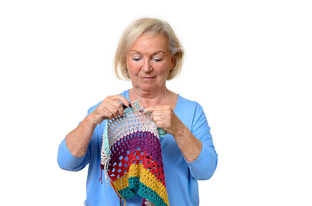 istock Attractive blond senior lady doing her knitting 524393244