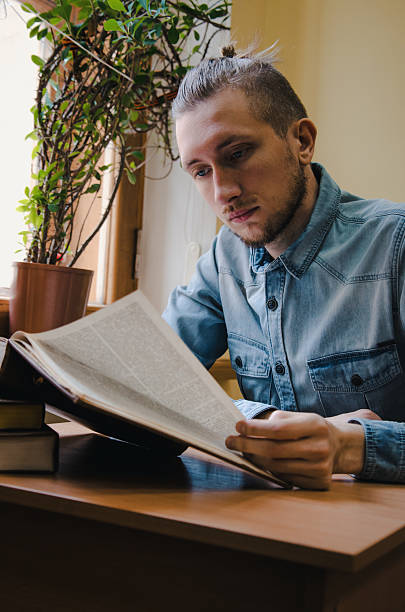 istock Intelligent bearded male hipster student reading book. Education school concept. 524393534