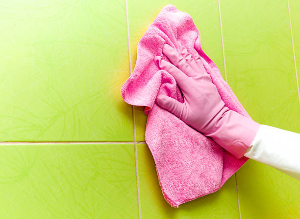 istock Maid cleans tiles with pink rag. Early spring cleaning. 524395306