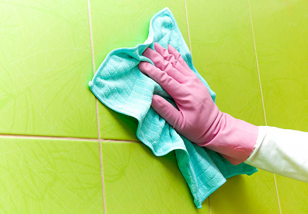 istock Protective glove cleaning tiles with blue rag. Early spring cleaning. 524395554
