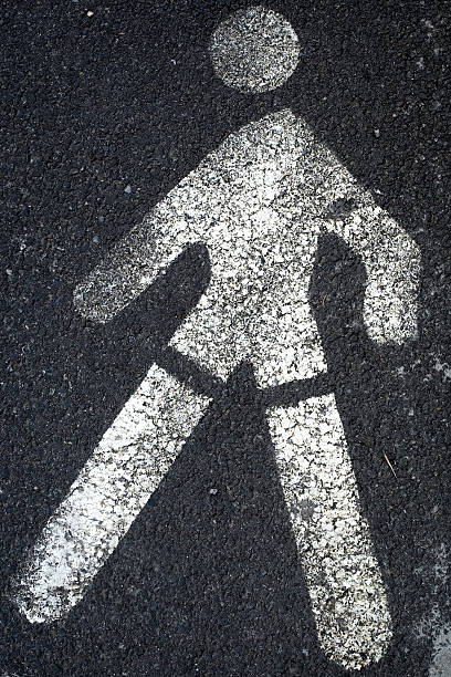 istock crosswalk man sign on pavement 524396290