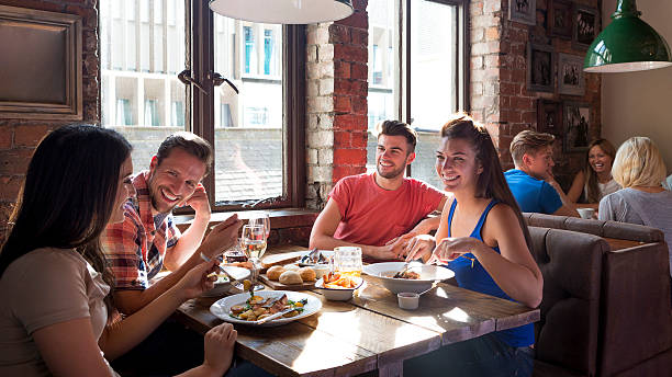 amigos desfrutar de uma refeição - gastro pub imagens e fotografias de stock