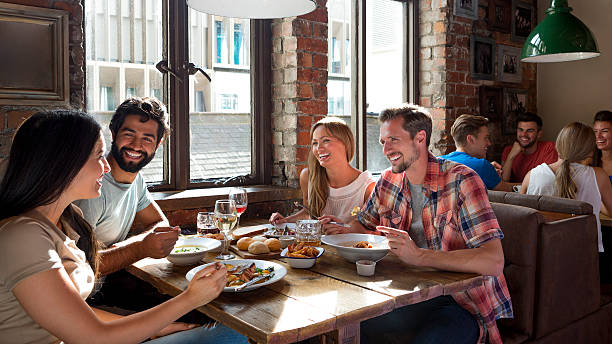 amigos desfrutar de uma refeição - gastro pub imagens e fotografias de stock