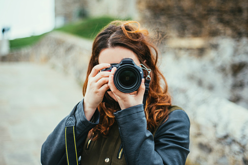 A young woman using a DSLR camera